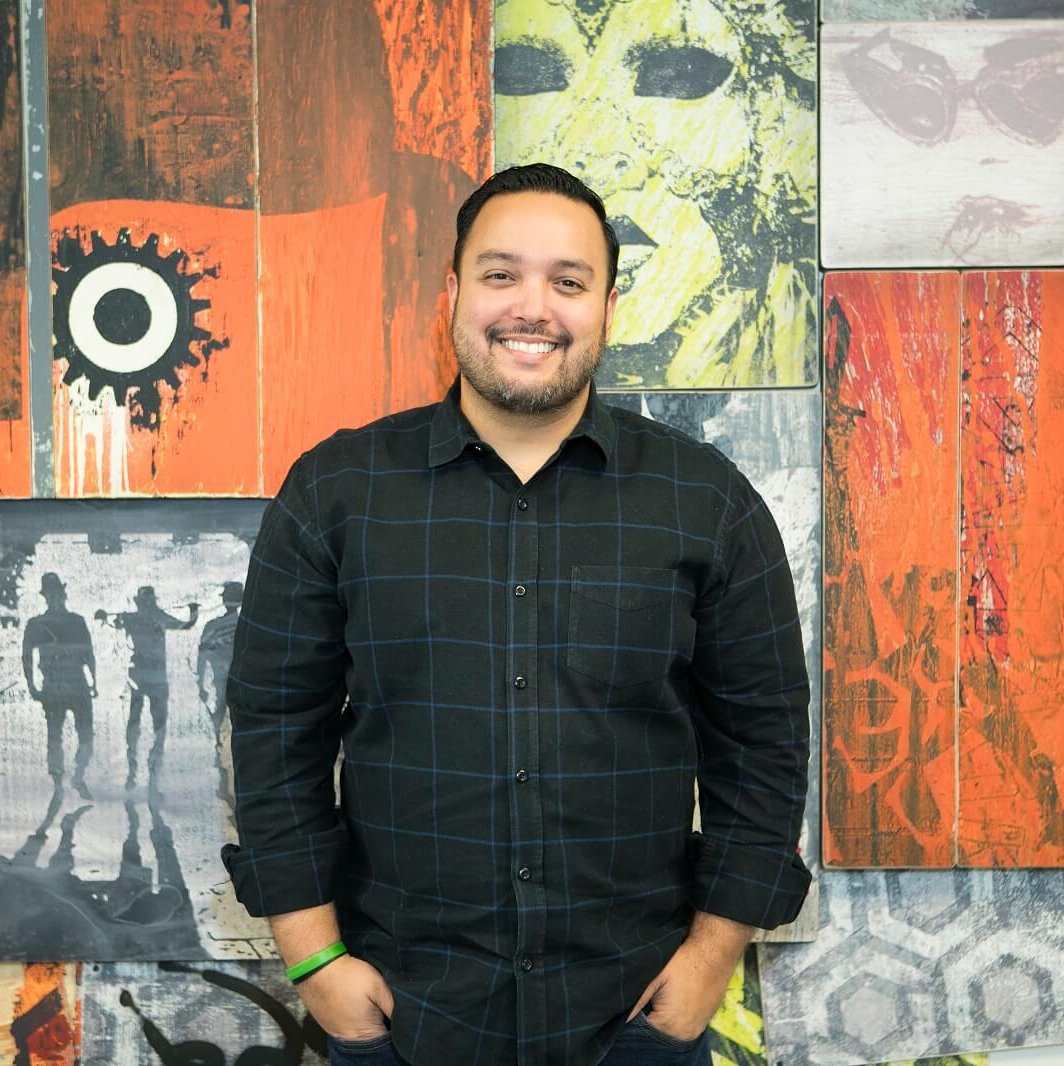 George Brea standing in front of a colorful wall